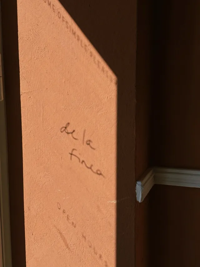 The handwritten de la finca sign on the terracotta wall